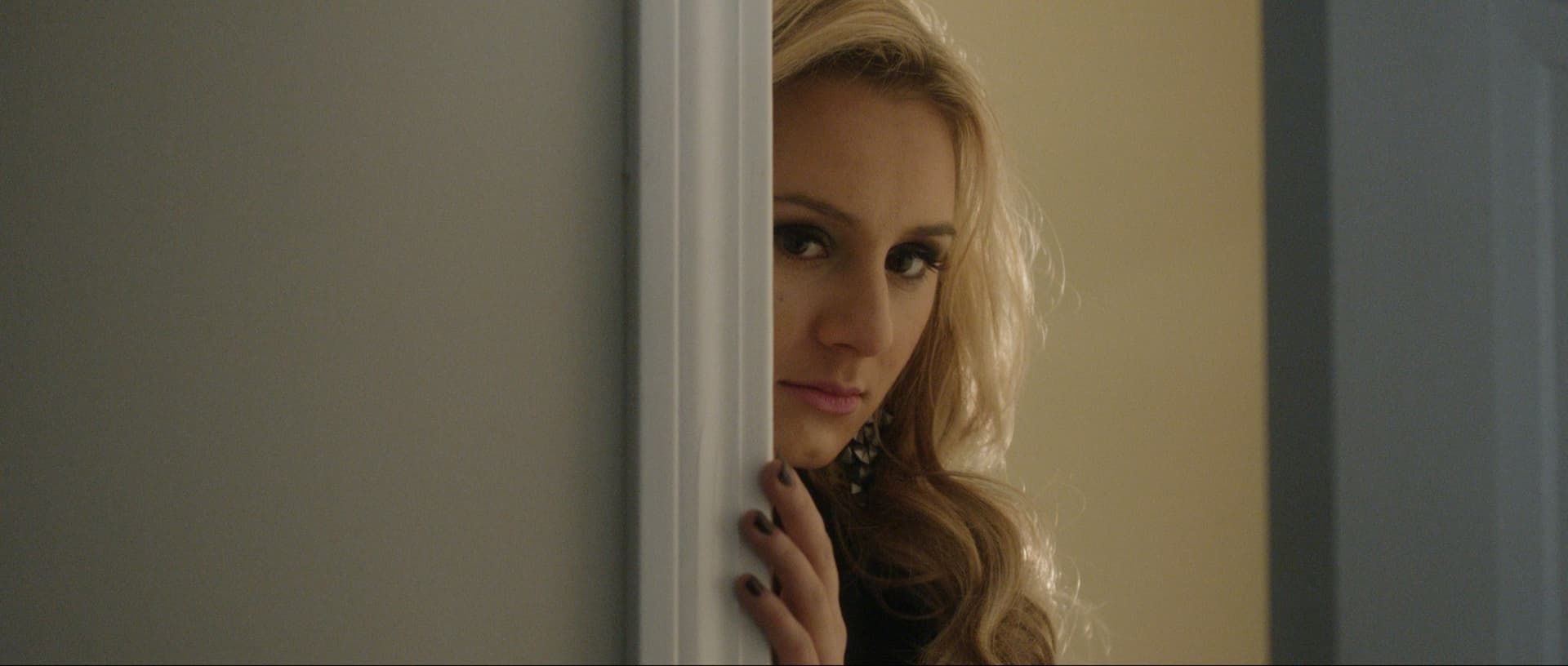 Woman peeking from behind a door, featuring long hair and a thoughtful expression.