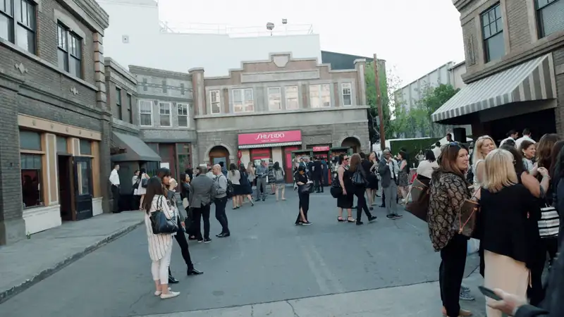 Crowd gathering on a stylish street for a Shiseido event, showcasing urban architecture and social atmosphere.