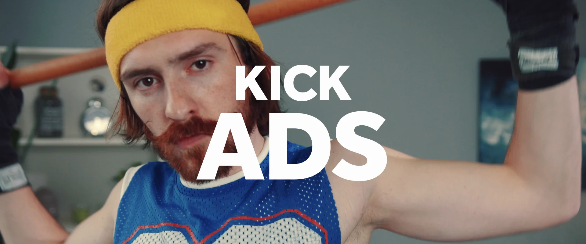 Man in athletic wear with a bat, focused on kicking ads.