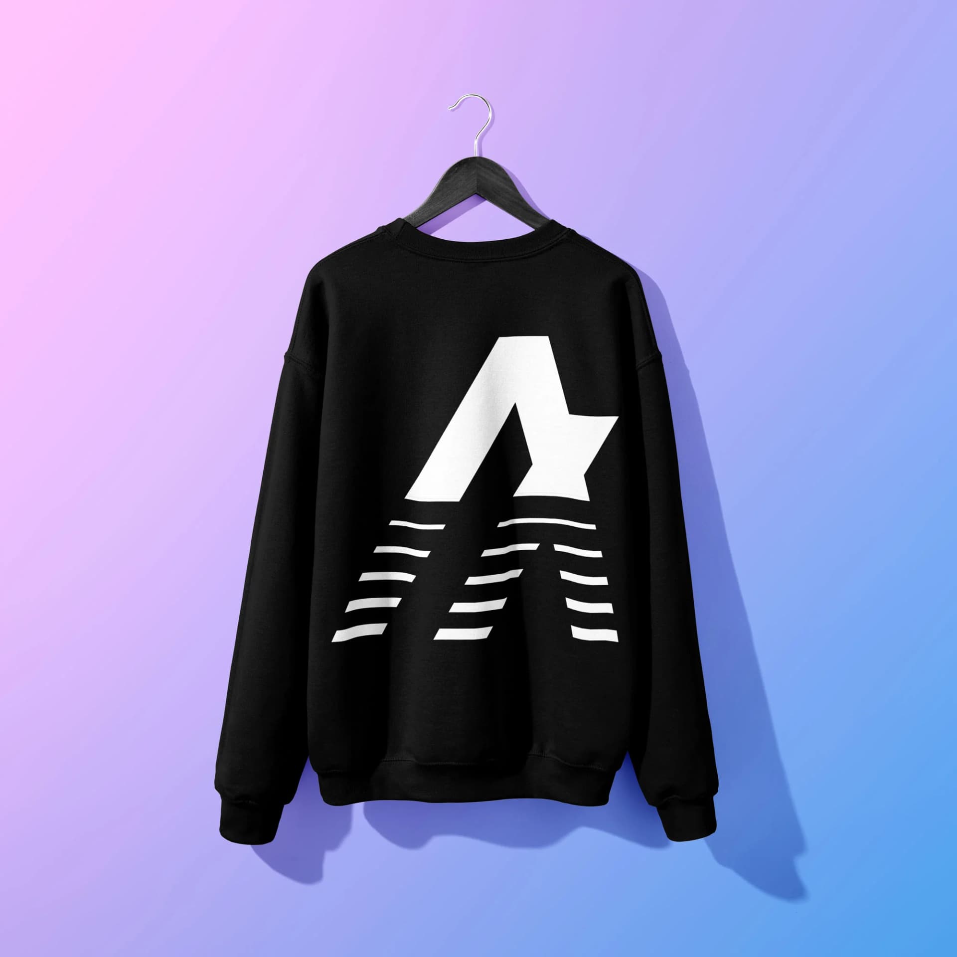 Black sweatshirt with white graphic design hanging on a pastel background.