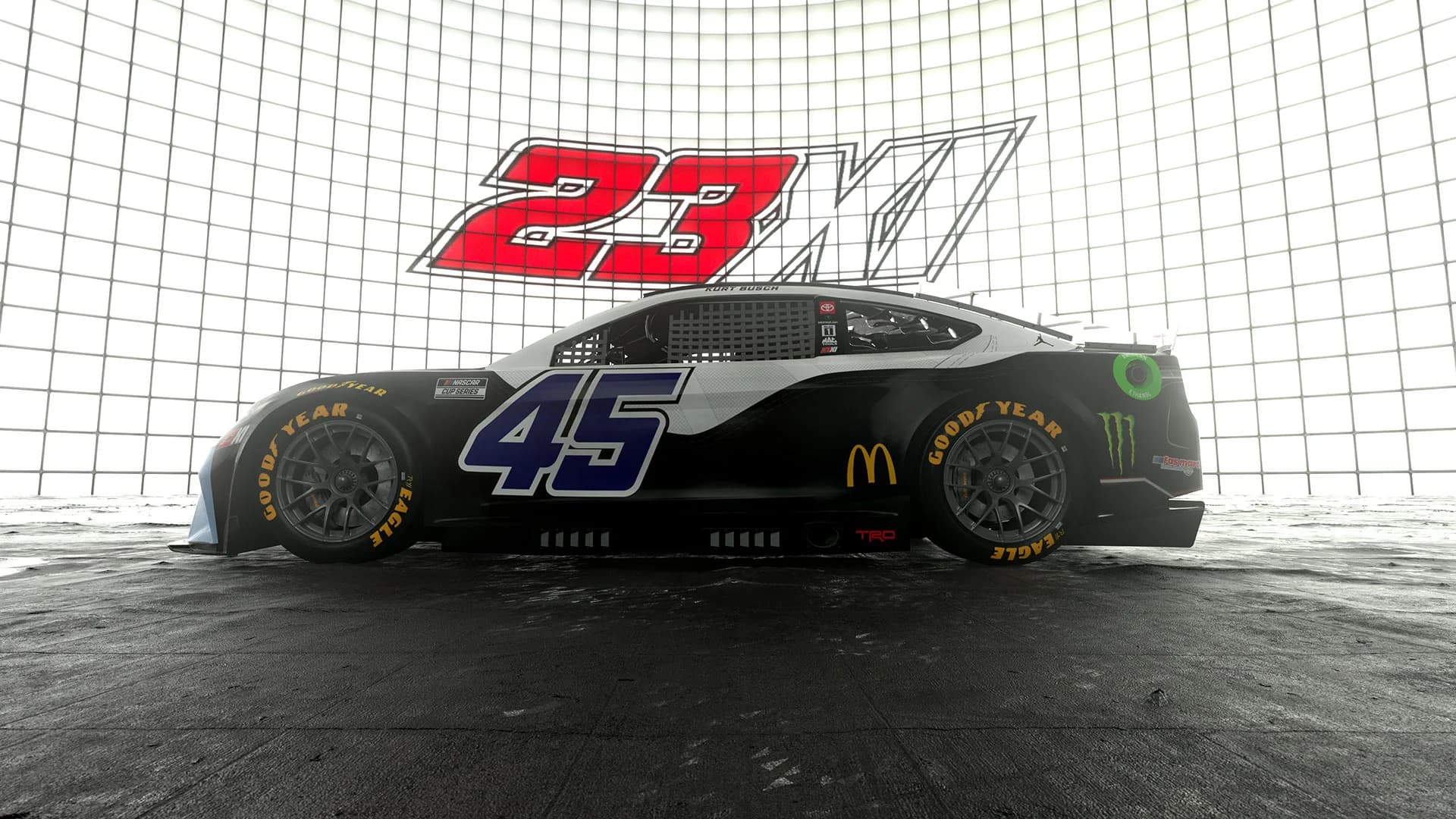 Side view of a black NASCAR car with number 45 and sponsors, displayed in a studio.